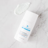 White cream container with blue label on a marble surface